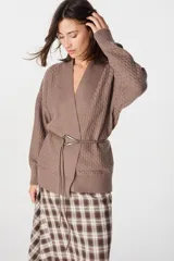 Saco tipo cardigan de punto color marrón, con diseño de textura geométrica, escote en V cruzado y cierre mediante un cinturón fino de cuero con hebilla metálica. Presenta mangas largas con puños acanalados y un corte holgado.