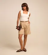 Bermuda sastrera color beige con estampa de raya de tiza, corte alargado, cinturón fino en la cintura y pliegues.