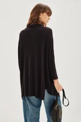 Cardigan largo tipo poncho o chalina, color negro liso, de tejido suave y caída fluida.