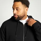 Buzo de chándal negro con cremallera frontal, capucha ajustable con cordón y bolsillos laterales.