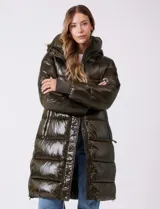 Campera puffer larga de abrigo marca BCBG Maxazria, color beige. Cuenta con capucha desmontable, cuello alto envolvente, cierre frontal bidireccional con solapa de botones a presión, bolsillos laterales, puños internos elastizados y tajos laterales con cierre en el bajo.