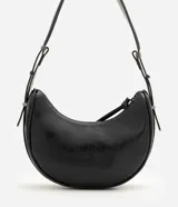 Cartera tipo baguette Satinato color negro, de estructura curva y acabado charolado uniforme. Cuenta con cierre superior y asa ajustable con hebilla metálica.