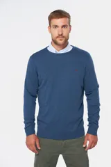 Buzo de punto color verde oscuro, con cuello redondo y mangas largas.