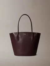 Cartera tote Calvin Klein de color marrón oscuro, con doble asa de hombro, cierre de cremallera superior y monograma metálico dorado en la parte frontal.