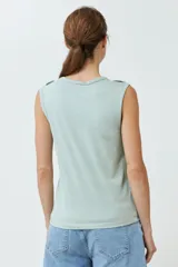 Musculosa de algodón color rojo, con cuello redondo, corte sin mangas y detalle de botones decorativos en los hombros.