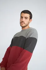 Sweater de tejido de punto con diseño color block en tonos verde, azul y gris. Presenta cuello redondo, mangas largas y corte regular.