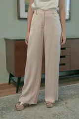 Chaqueta de tweed color crema con flecos en cuello, puños y ruedo. Tiene doble botonadura dorada y bolsillos frontales de parche.