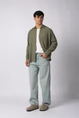 Camisa de manga larga confeccionada en tejido de lino con textura, de corte holgado y diseño versátil con cierre frontal de botones.