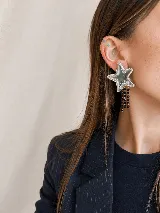 Aros grandes de acrílico espejado con diseño de estrella, decorados con tres tiras de cadena colgantes con cuentas negras.