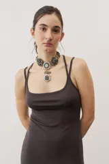Vestido largo color verde suave, sin mangas, con escote redondo y silueta al cuerpo que se ensancha levemente hacia el dobladillo.