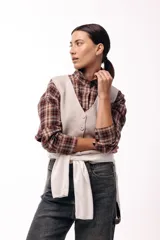 Chaleco tejido de punto con escote en V y cierre frontal con botones. Presenta una silueta recta y un diseño minimalista.