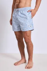 Short de baño con estampado botánico en tonos tierra, rosados y verdes. Presenta cintura elástica con cordón ajustable y un pequeño parche con logo en el ruedo.