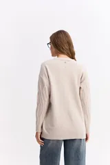 Buzo de punto color celeste con diseño de trenzas en relieve, cuello redondo y mangas largas con puños acanalados.