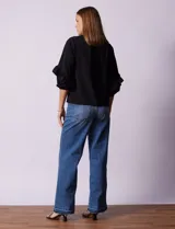 Blusa de gasa estampada con flores azules y violetas sobre fondo blanco, de manga 3/4 con volados.