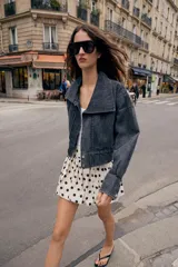 Falda pantalón de estilo globo con diseño abullonado y estampado de lunares negros sobre fondo crudo. Presenta cintura alta y cierre lateral con cremallera oculta.