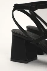 Sandalias de cuero negro con punta cuadrada, taco geométrico y tiras finas.