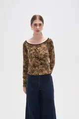 Remera de manga larga con cuello bote, confeccionada en tejido con estampado animal print tipo leopardo y borde negro en el escote.