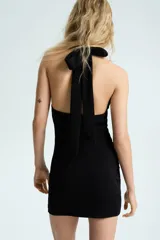 Vestido mini negro con escote halter drapeado y laterales fruncidos, confeccionado en punto roma de ajuste ceñido.