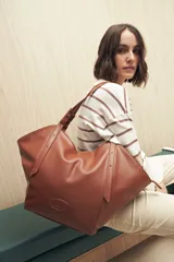 Bolso tote grande color marrón, con correa larga regulable para usar al hombro.