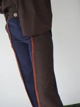 Pantalón de paño combinado con tira de cuero color marrón.