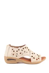 Sandalias de cuero color beige con diseño de perforaciones circulares en toda la capellada, taco bajo y suela anatómica.