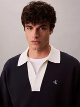 Sweater oversize de punto azul marino con cuello johnny y solapas en contraste color blanco, de manga larga, con logo de Calvin Klein bordado en el pecho.