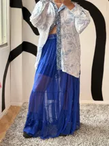 Pollera larga de microtul color azul francia, con elástico en la cintura y volados en el ruedo.