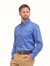 Camisa de vestir color celeste, de manga larga, con cuello abotonado y bolsillo frontal con logo bordado.
