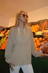 Canguro beige de tejido waffle con capucha, mangas largas y cierre parcial con botones.