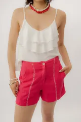 Musculosa negra con escote en V, breteles finos regulables y doble volado frontal con pespuntes.