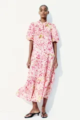 Vestido largo de algodón color rosa con estampado floral, cuello mao, mangas globo cortas, cinturón fino extraíble y falda acampanada con fruncido escalonado.