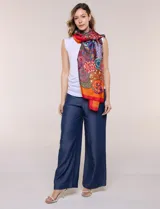 Pashmina rectangular de satén con acabado brillante y caída fluida, con un diseño de estampa gráfica multicolor en toda la superficie y terminaciones con dobladillo fino.