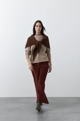 Polera de tejido de punto color gris oscuro, con cuello alto y diseño de rombos en relieve en el frente. Presenta un calce relajado con terminaciones en rib en cuello, puños y ruedo.