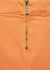 Pantalón capri de tiro medio con cierre frontal de cremallera, corte ajustado y diseño de cinco bolsillos.