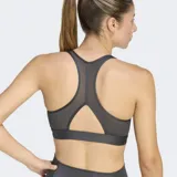 Top deportivo Adidas de bajo impacto, confeccionado en tejido técnico con tecnología AEROREADY de absorción de humedad. Presenta un diseño de espalda racer-back, cuello escotado y banda elástica inferior para mayor soporte, con el logo de la marca estampado en el frente.