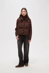 Campera híbrida con cuerpo delantero acolchado tipo puffer y mangas de tejido de punto acanalado con cuello alto. Presenta un diseño corto y holgado con cierre frontal oculto.