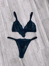 Conjunto de lencería de encaje color azul, compuesto por un bralette de triángulo con breteles regulables y una bombacha tipo colaless con tiras laterales.