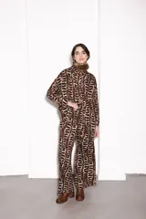 Pantalón de vestir marrón con estampado abstracto en negro y blanco.