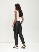 Pantalón negro de cuero sintético con cintura elástica y corte recto.