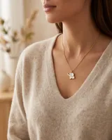 Collar de bronce dorado con cadena fina y dije en forma de elefante con incrustación de nácar blanco.