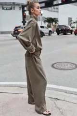 Pantalón de tiro alto con pernera recta, cintura elástica en la parte posterior y nervio marcado en el frente. Cuenta con cierre frontal de botón y ganchos, bolsillos delanteros y bolsillos de plastrón en la parte trasera.