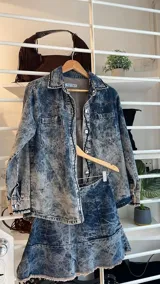 Minifalda de denim liviano con efecto acid wash, corte evasé con volado en el ruedo con terminación desmechada y cierre metálico en el costado.
