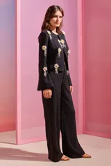 Pantalones rectos de punto jacquard con lúrex color negro, con cintura estructurada, botón dorado y bolsillos laterales.