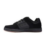 Championes de skate DC modelo Manteca 4, color negro con suela de goma color caramelo. Presentan diseño robusto con paneles de gamuza y cuero sintético, logo de la marca en el lateral y lengüeta acolchada.