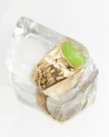 Anillo de acero quirúrgico hipoalergénico color dorado, con forma irregular y piedra central verde. Talle 17 ajustable.