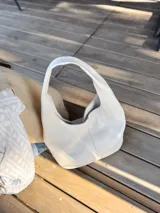 Bolso tote de cuero color crudo, con doble asa corta y diseño minimalista.