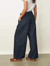 Jean de corte wide leg en color azul oscuro, con cintura elástica ajustable mediante cordón y cierre frontal con botón.