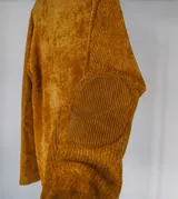 Sweater de chenille color mostaza, de cuello redondo, con mangas largas y apliques de pana acanalada en los hombros decorados con botones.