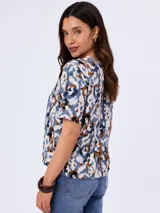 Blusa de viscosa con cuello redondo y mangas cortas, con diseño estampado en tonos azules y blancos.