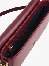 Cartera rectangular de color borgoña con acabado liso y solapa frontal con cierre magnético. Presenta un monograma TH en relieve en la parte delantera. Incluye correa ajustable y extraíble para llevar al hombro o como cartera de mano.